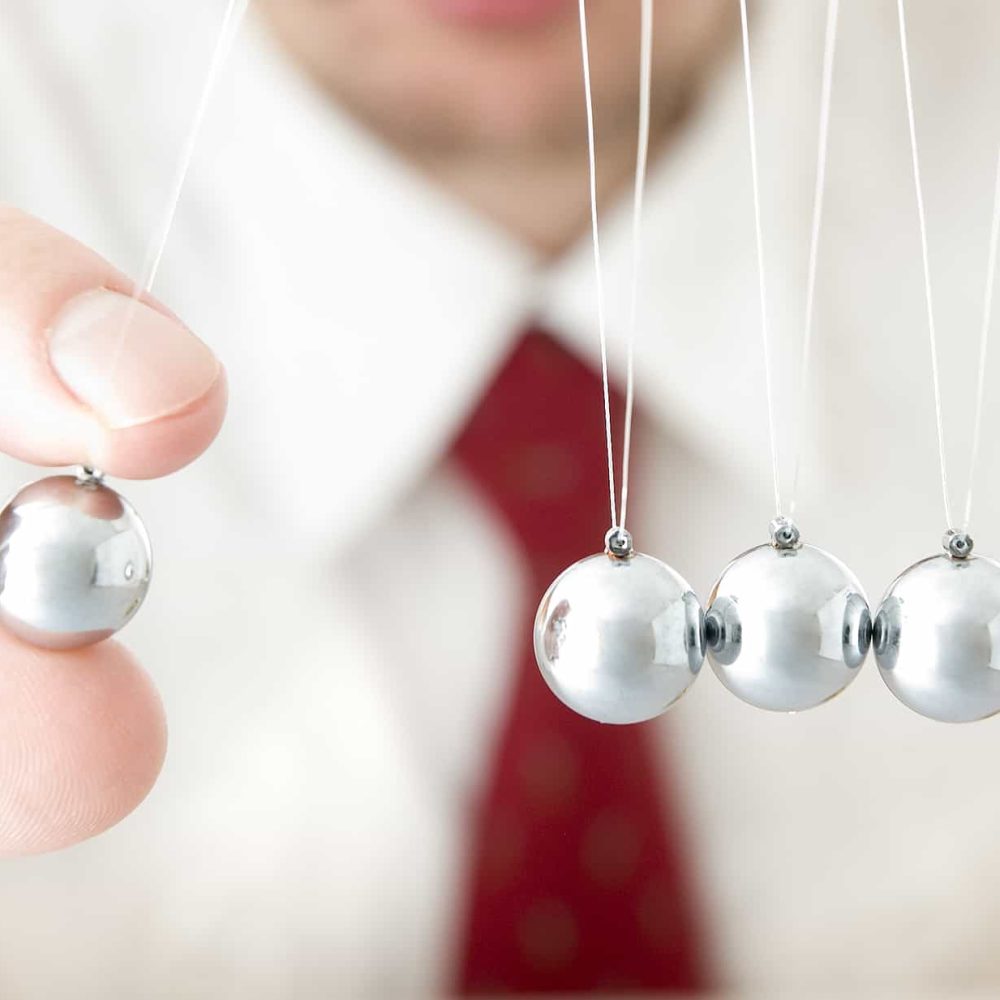 businessman holding a pendulum ball